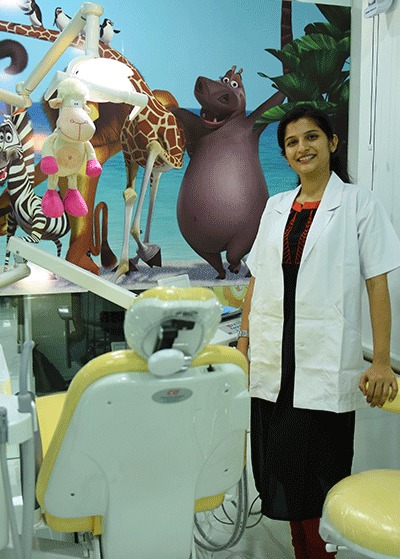 A child dentist smiles at the camera in a dental office, demonstrating her happy dental experience