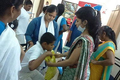 A female dentist and an assistant assist a young boy in checking oral hygiene at a dental check-up.