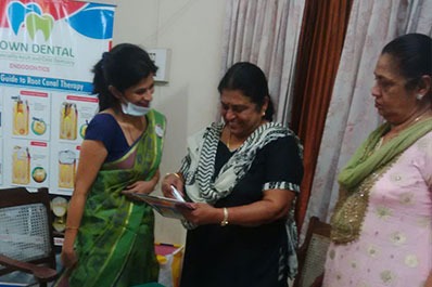 A woman dentist doctor discussing dental treatment with her clients in a dental clinic Coimbatore.