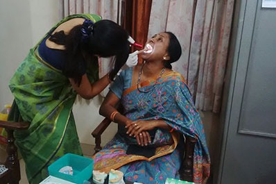 A female dentist doctor checking a woman about her oral hygiene at a dental clinic in Coimbatore.