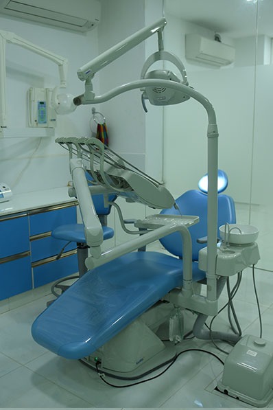 A dental chair & dental equipment in a clinical area are ready for high-quality dental treatment.