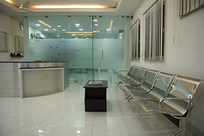 The welcome room of the top dental clinic comes with chairs and a transparent glass wall.