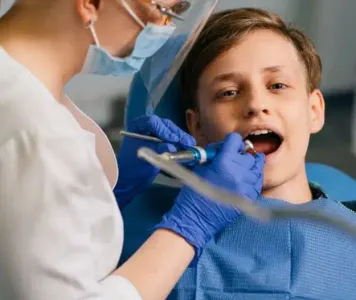 A young receiving a dental check-up from a dentist specializing in pediatric dentistry treatments.